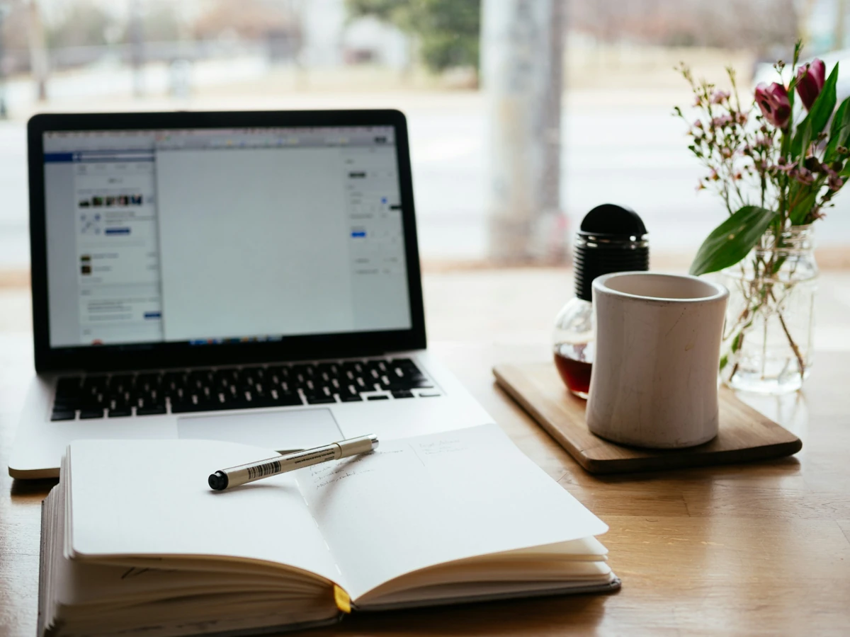 Laptop and notebook on a desk for planning a workflow