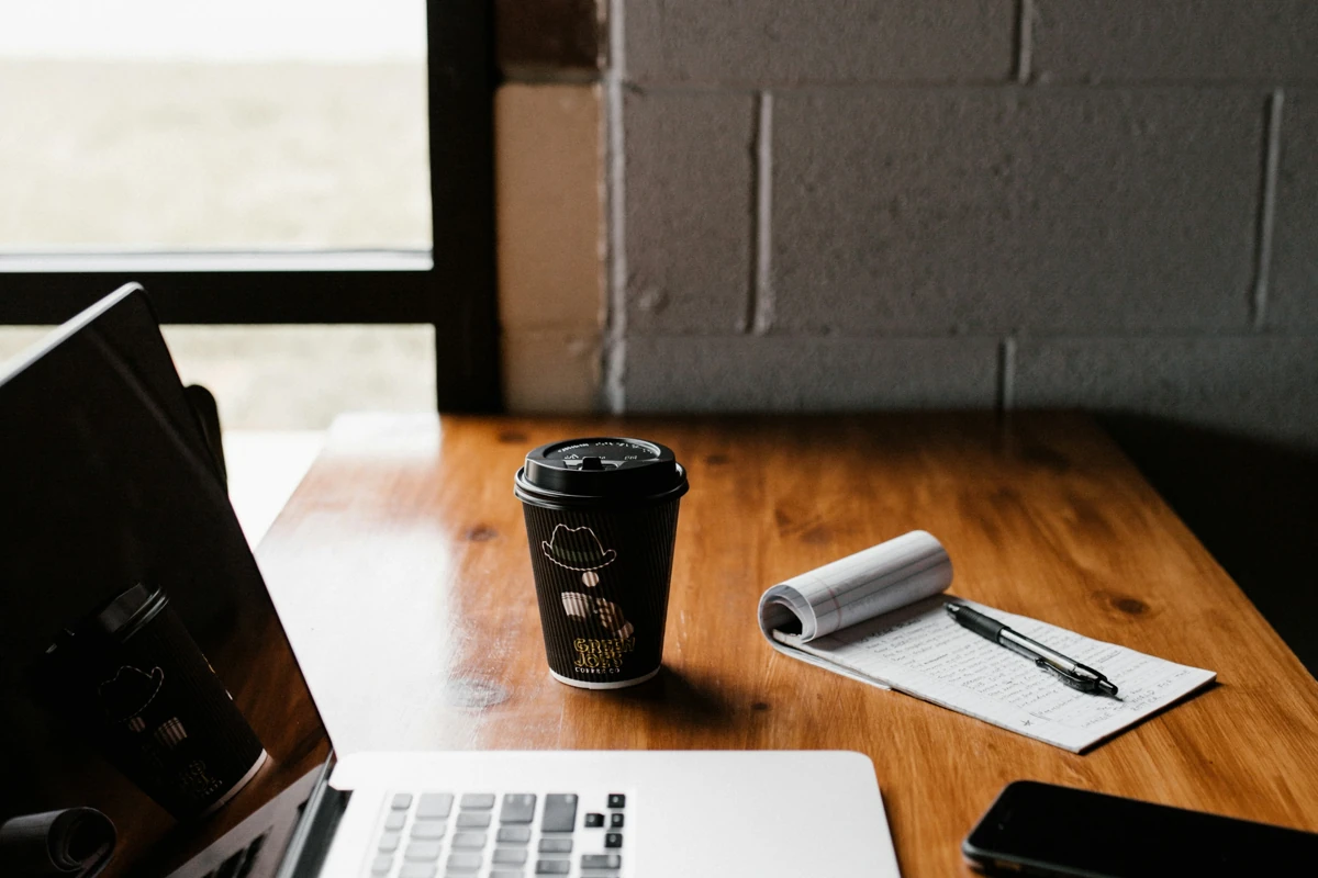 Laptop, coffee and planning notes on a desk