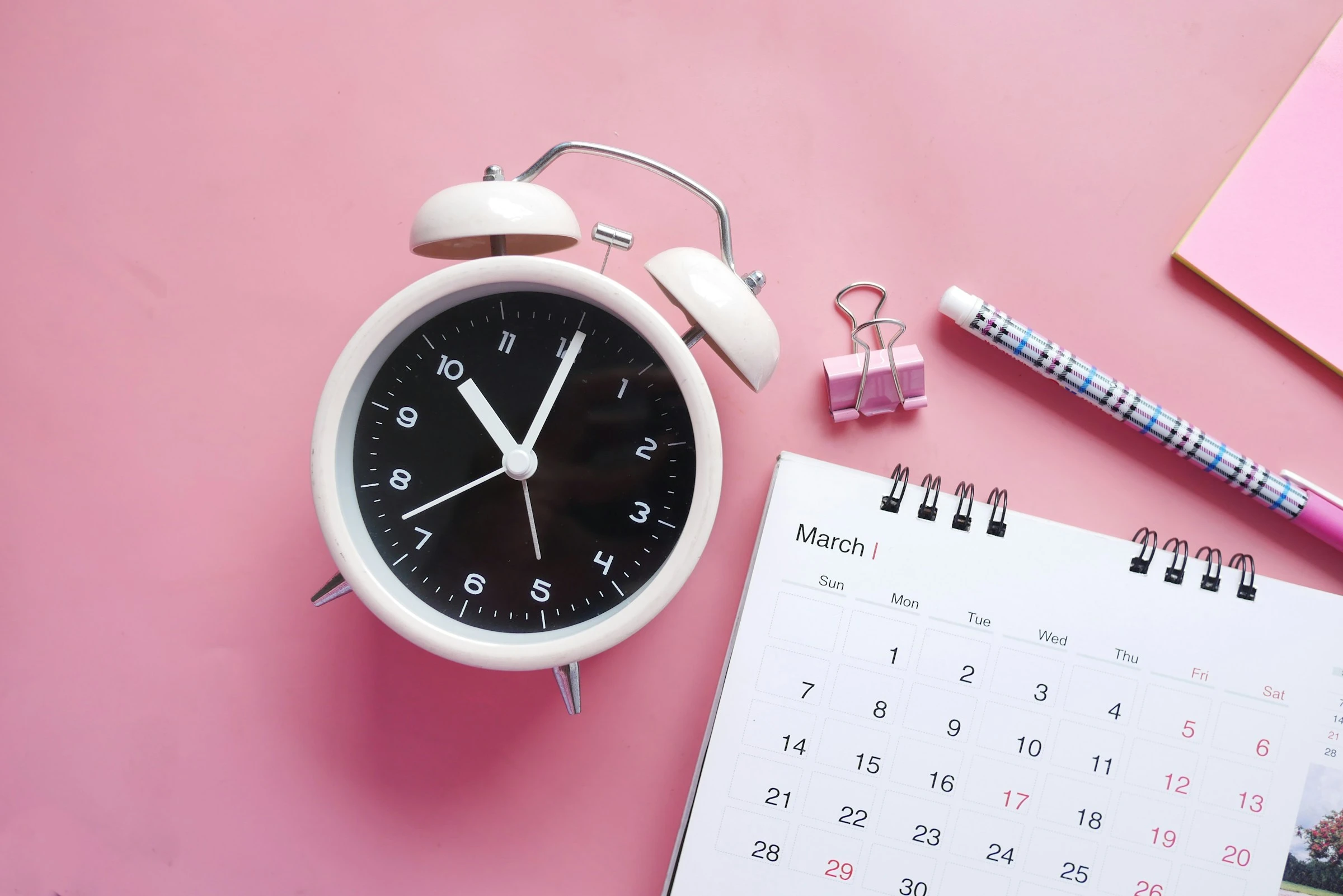 Desk calendar and alarm clock illustrating a deadline