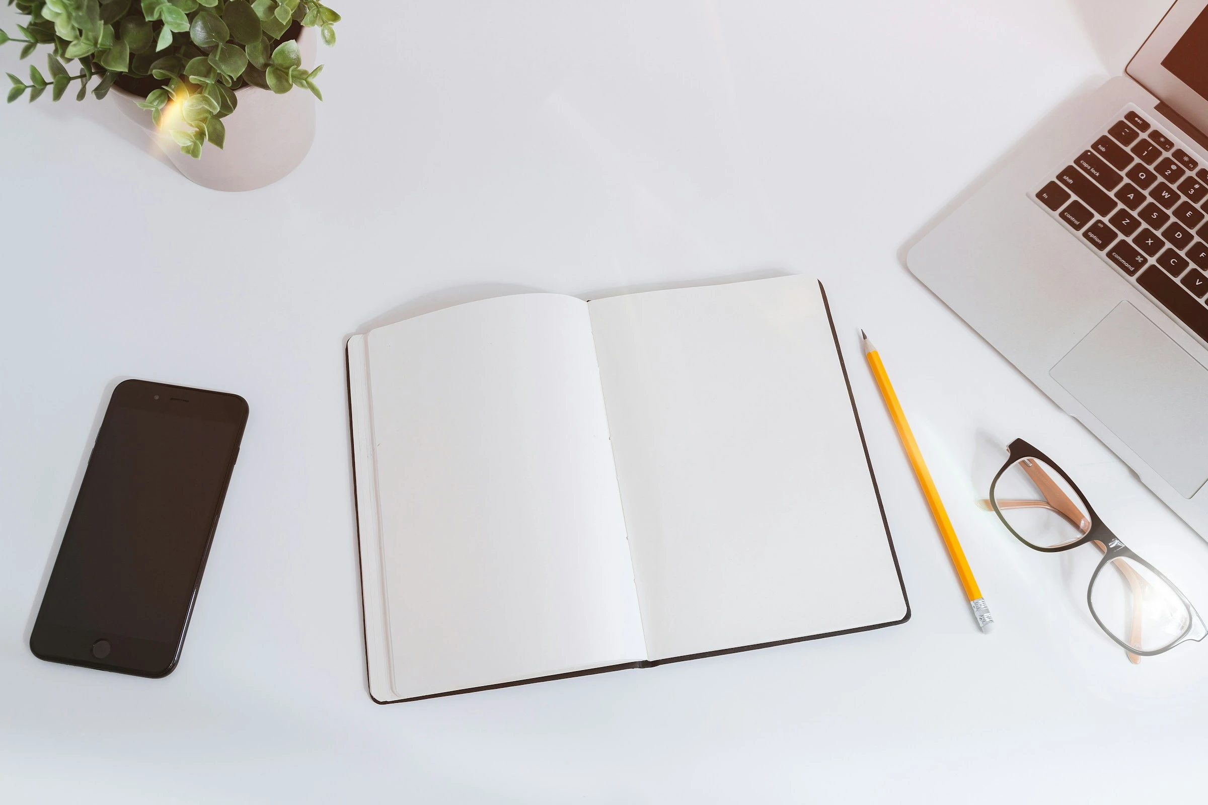 Notebook, laptop and phone arranged for planning